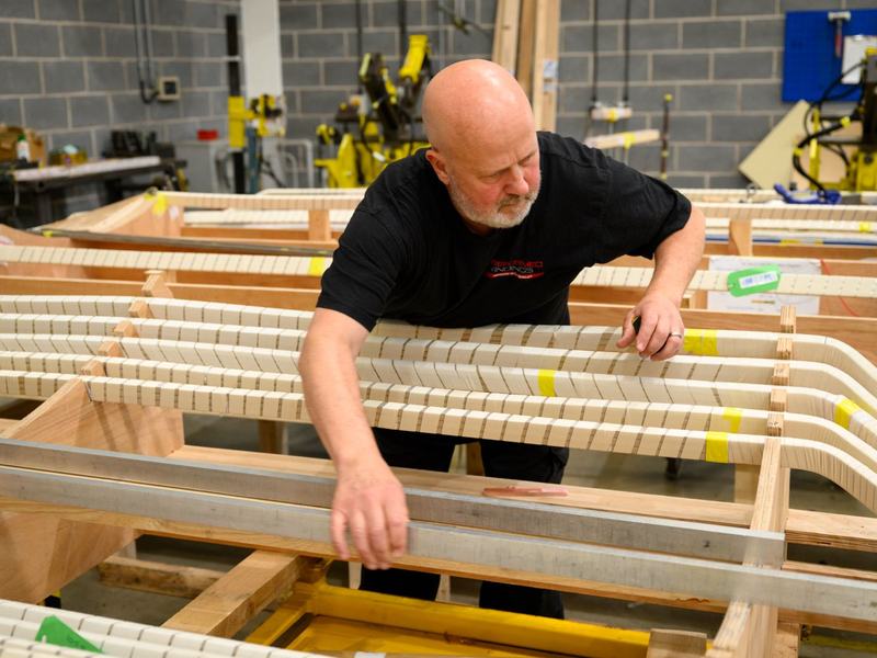 Worker adjusting High Voltage Coil within jig
